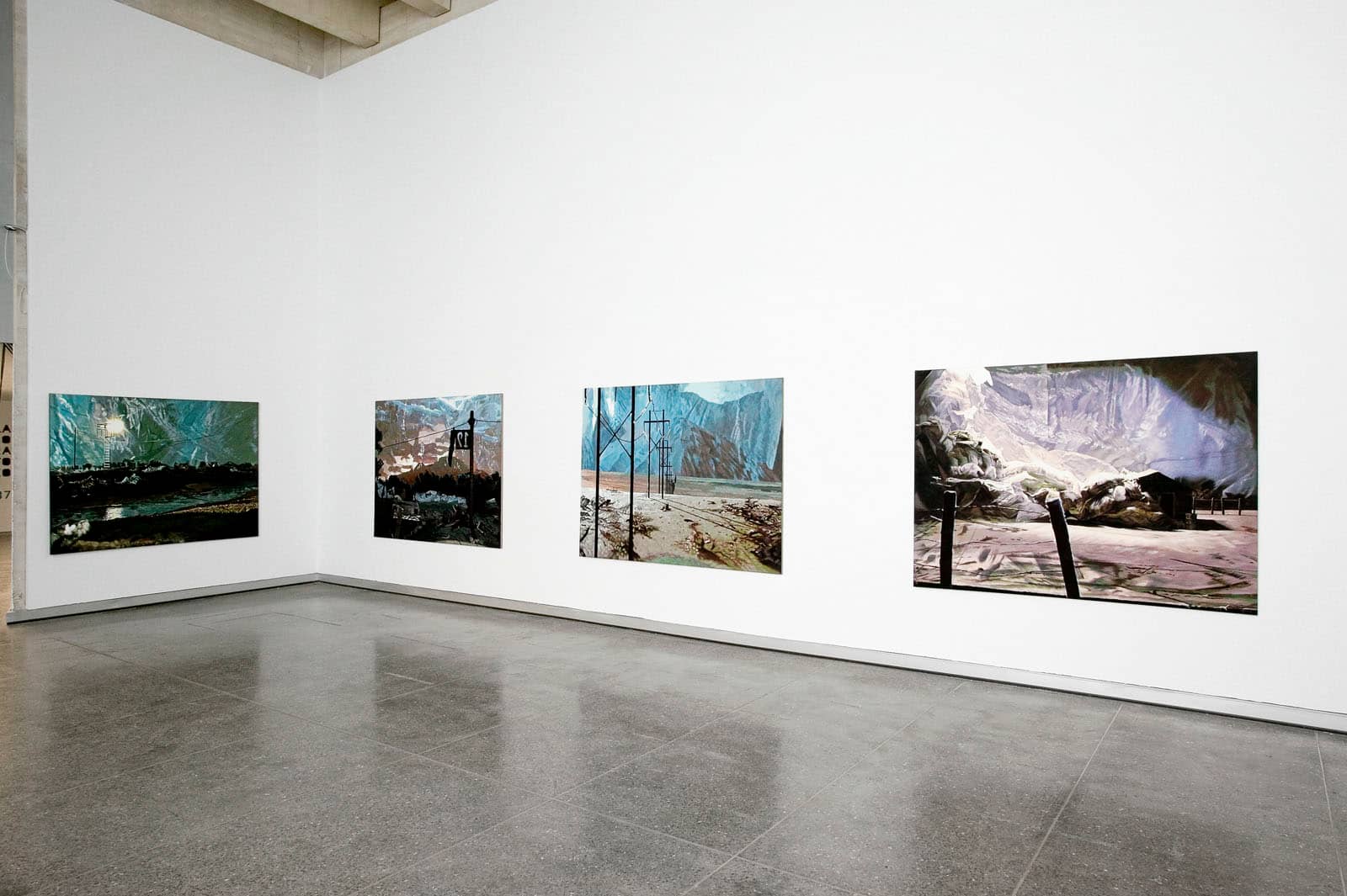 Exhibition view of the solo exhibition "Exvoto, Where is Nikki Black" by Philipp Fröhlich at MUSAC museum in Leon, Spain, curated by Tania Pardo. The image shows four horizontal paintings showing landscapes.