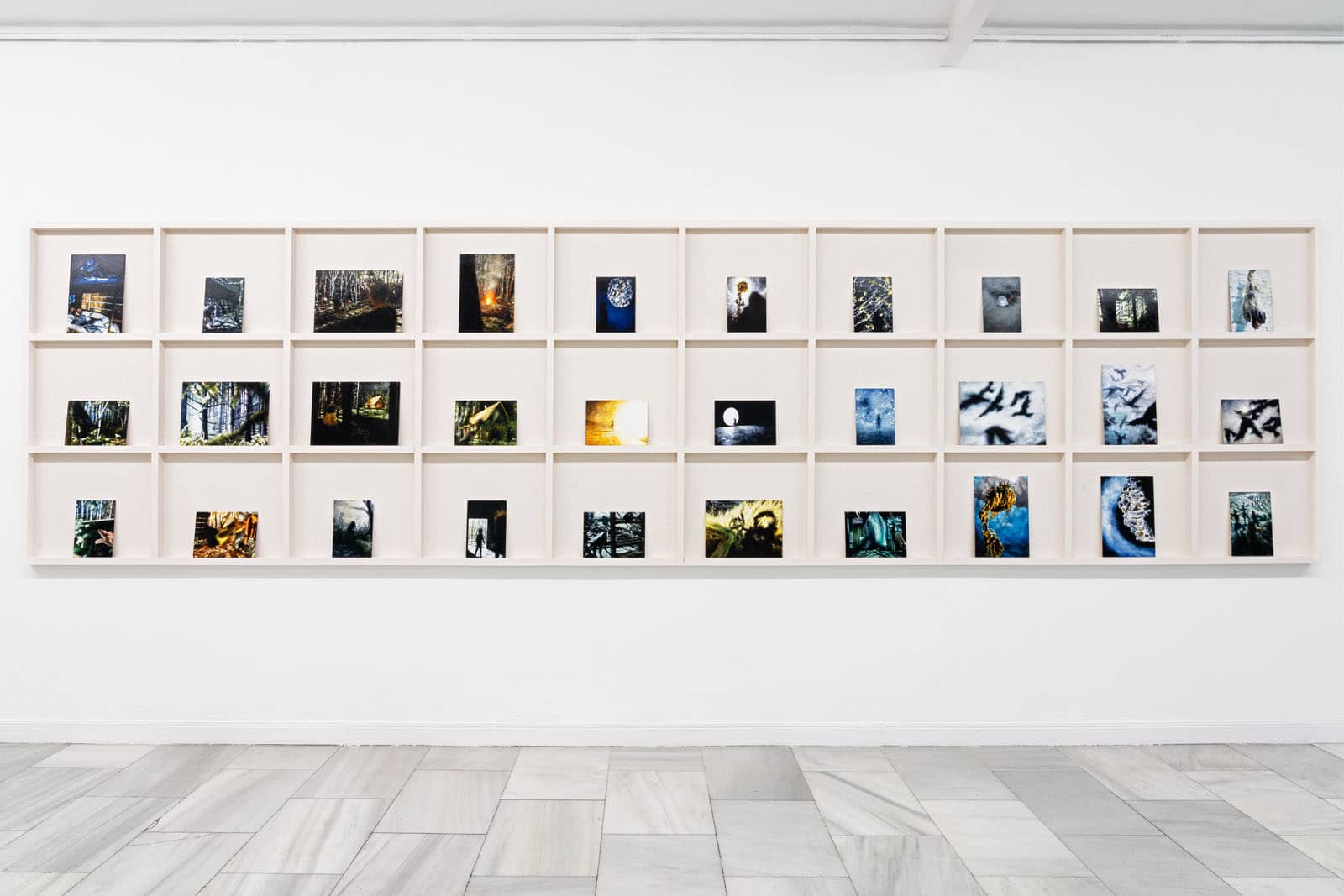 Exhibition view of the solo show "Falada" by Philipp Fröhlich at Juana de Aizpuru gallery in Spain, 2022. The image shows a shelf with 32 small scale oil sketches on panel at the gallery.